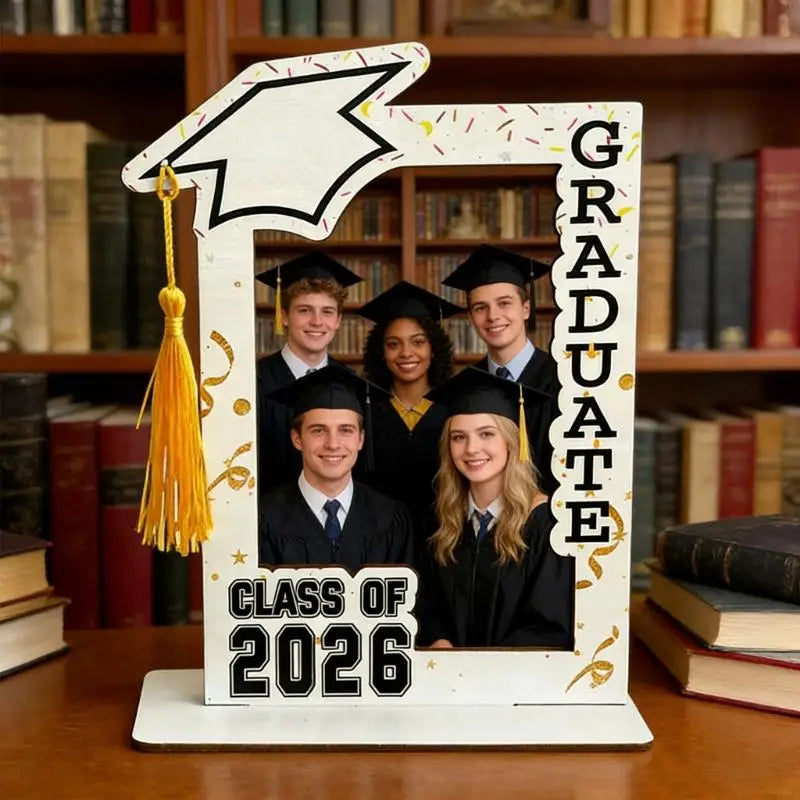 A wooden graduation photo frame displaying four smiling graduates in black gowns and caps.
