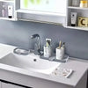 A bathroom sink setup featuring a chrome faucet, silicone splash guard, and drying mat on a white countertop.
