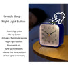 A blue digital alarm clock with a night light feature is shown on a wooden surface.