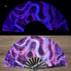 A folding fan with a vibrant, iridescent pattern showing various shades of purple and pink under UV light.