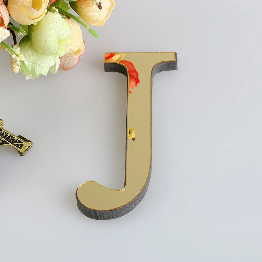 A gold letter mirror wall decal set featuring a large, three-dimensional capital letter U.