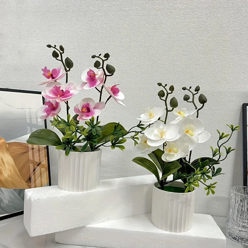 Artificial pink and white phalaenopsis orchids displayed in white pots on a white shelf