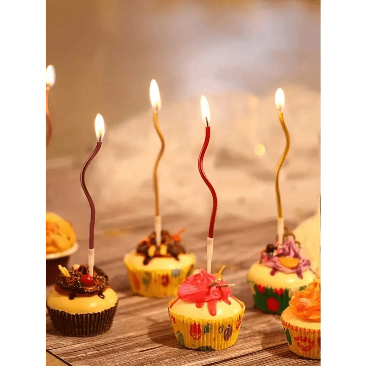 A display of spiral birthday cake candles with star toppers set against a soft, warm background.