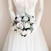 A bridal bouquet of white and ivory roses with a champagne finish held by a mannequin.