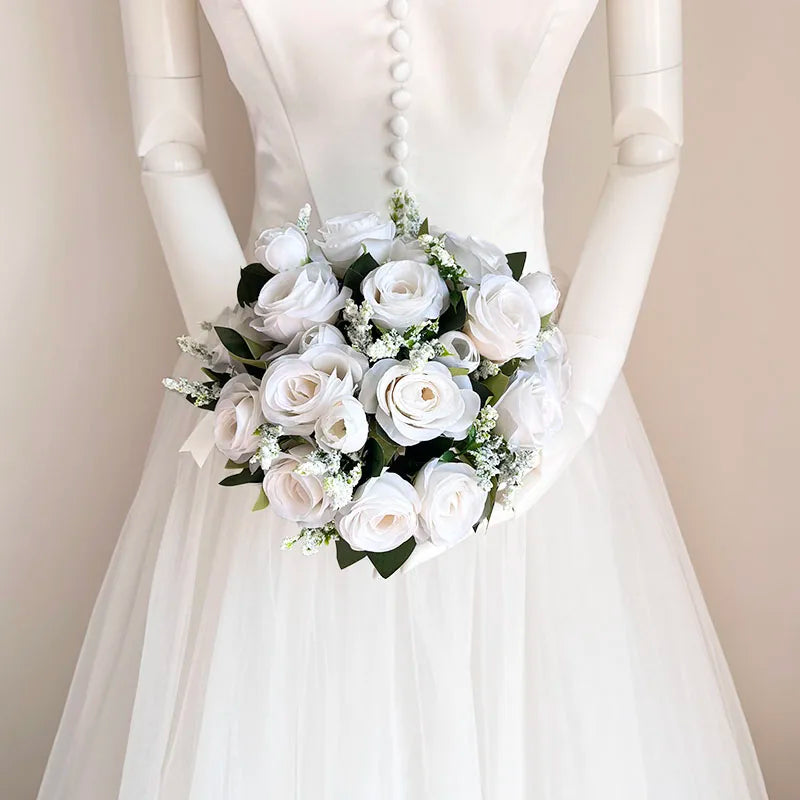 A bridal bouquet of white and ivory roses with a champagne finish held by a mannequin.