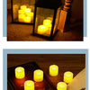 A close-up of several glowing yellow candles arranged on a wooden surface.