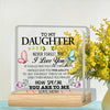 A personalized acrylic desk sign with a message to daughter and a floral background on a wooden base.