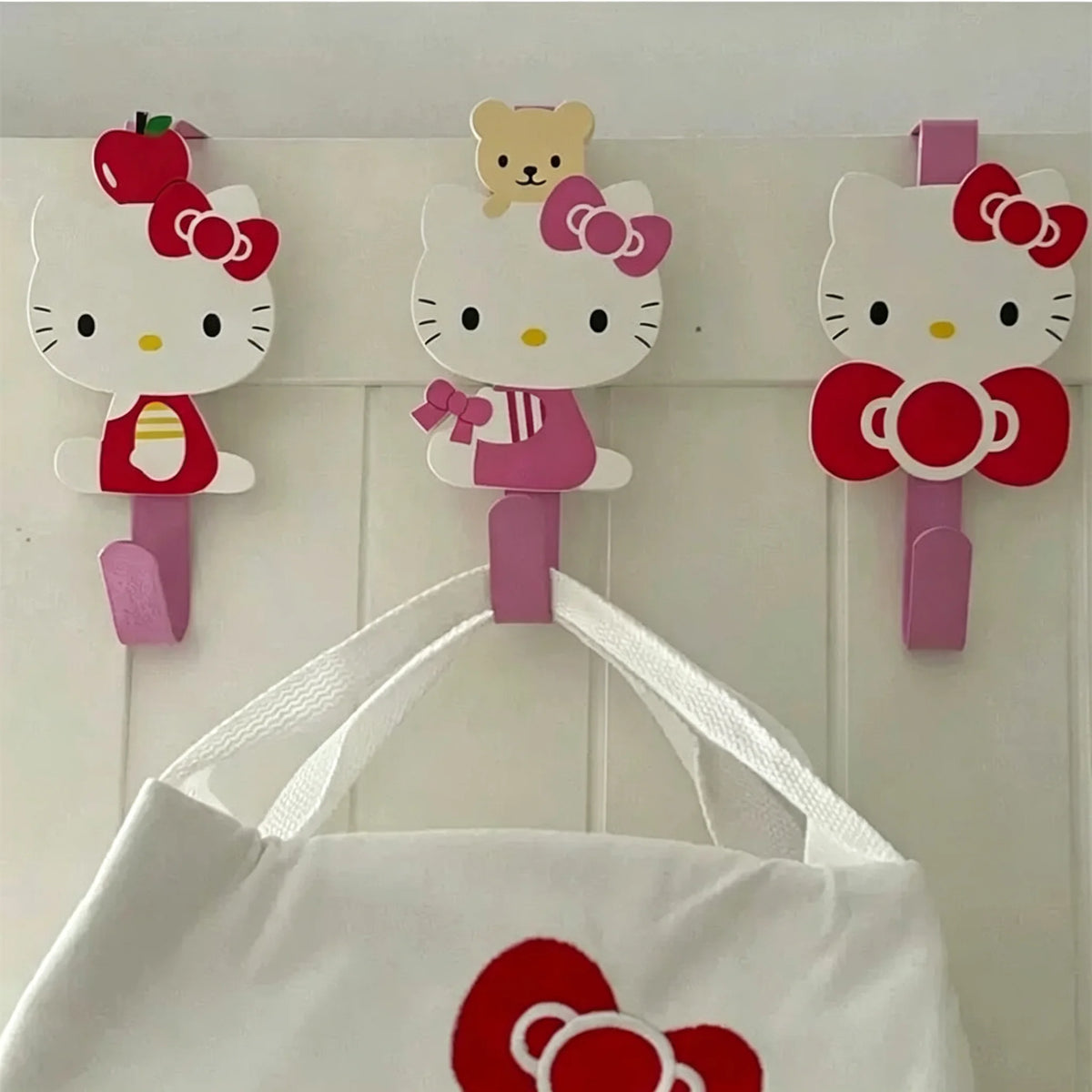 Three pink and white cartoon cat hooks for over-the-door hanging storage