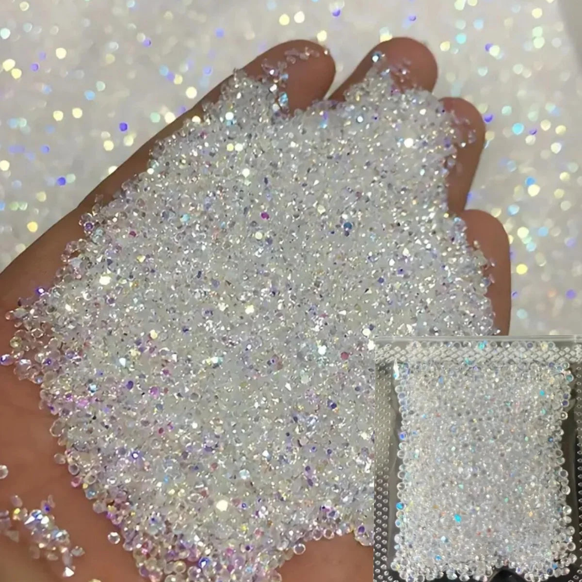 A hand is holding a pile of iridescent nail rhinestones for DIY art against a sparkling background.