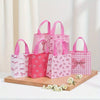 A collection of pink and white gift bags with heart cutouts, featuring various patterns and pink handles.