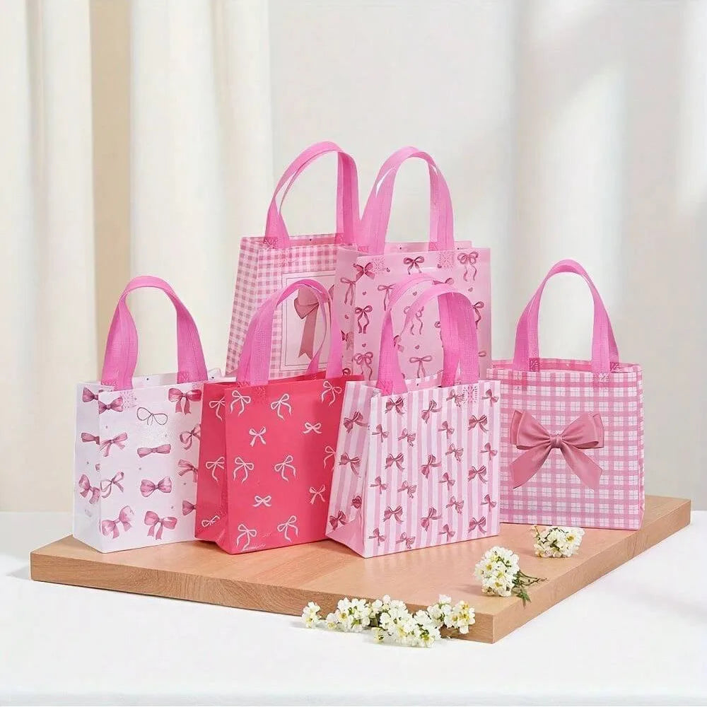 A collection of pink and white gift bags with heart cutouts, featuring various patterns and pink handles.