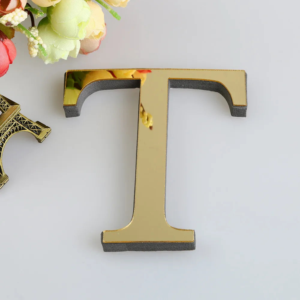 A gold letter T shaped wall decal with a mirrored finish, shown against a white background.