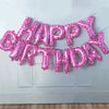 A pink foil balloon banner spelling out Happy Birthday decoration