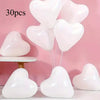 A collection of white heart-shaped latex balloons displayed against a pink background.