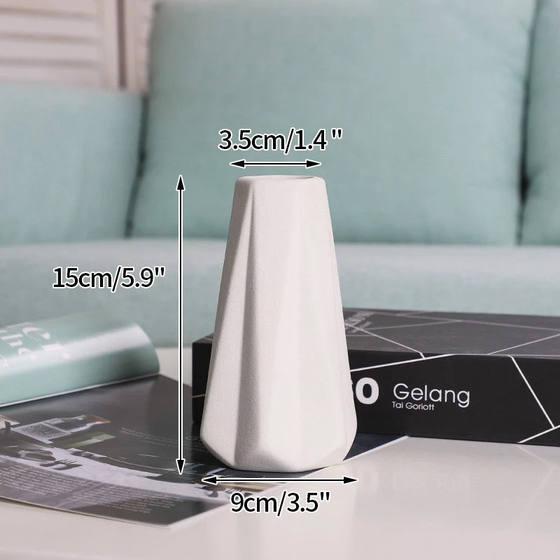 A white ceramic bud vase is shown on a table next to product measurements and a box.