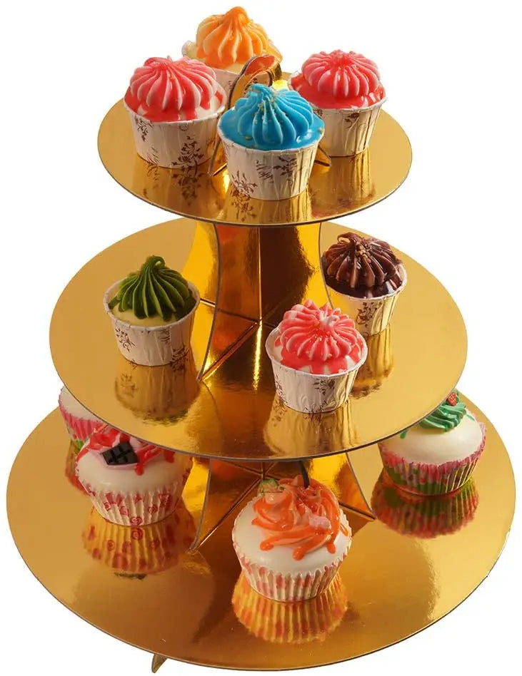 A three-tier rainbow cupcake stand displaying various colorful cupcakes on a gold pedestal.