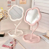 A pink sunflower heart dressing makeup mirror with a white frame and stand on a light surface.