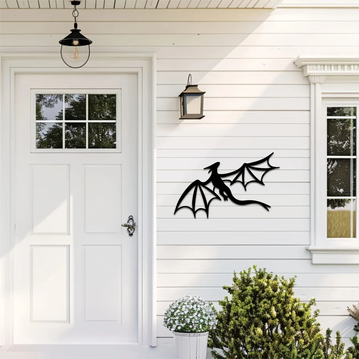 A white clapboard house exterior featuring a black dragon metal wall art panel mounted on the siding.