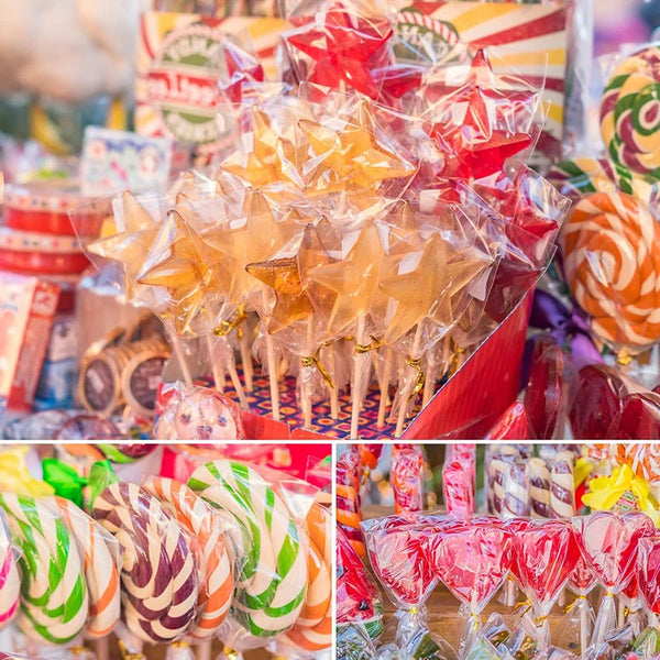 A close-up of a large quantity of colorful lollipops packaged in clear plastic with paper sticks and tie closures.