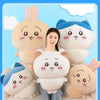 A woman is surrounded by several soft, pink and blue Chiikawa plush dolls, including a large one and smaller ones.