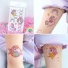 Colorful glitter unicorn temporary tattoos applied on an arm, with a sheet of the product visible.