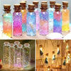 A collection of mini glass bottles with cork stoppers filled with colorful glitter and liquid for crafts and storage.