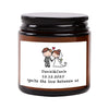 A dark glass jar with a black lid containing a label featuring a couple and the date 12.12.2025.