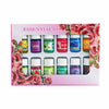 A set of essential oils in glass bottles with labels for Lavender, Rose, and other scents displayed against a pink background