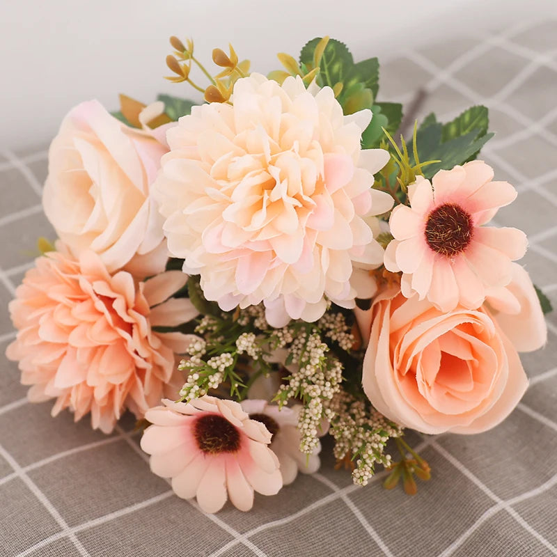 A bouquet of silk autumn roses and hydrangea flowers in soft peach and cream tones.