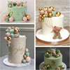 A collection of foam ball cake toppers in gold and green colors, including a teddy bear figure.