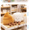 A collection of plush toys shaped like toilet paper, poop, and plunger, featuring soft textures in orange, white, and brown.