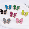 A collection of various colored pearl butterfly waist tightener buttons for jeans.