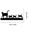 Black silhouette of a cat and several other cats on a horizontal metal bar for wall decor