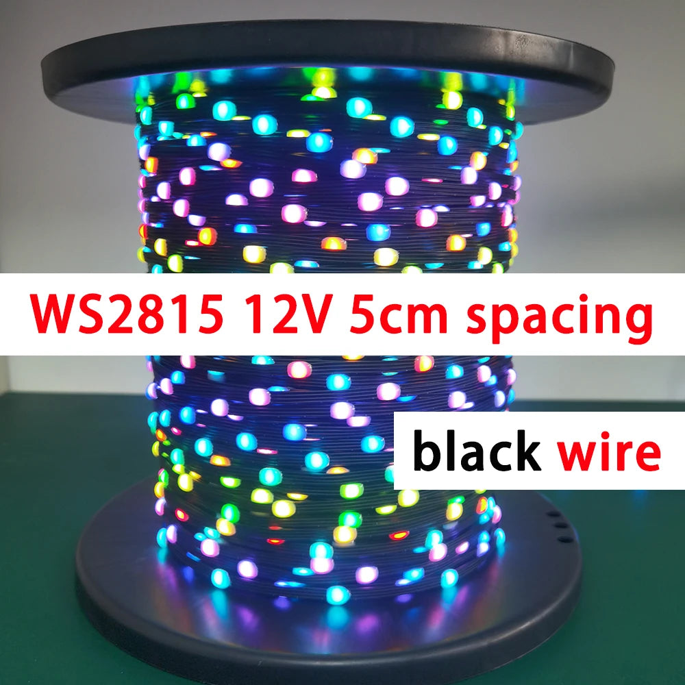 A close-up of a coil of WS2815 addressable LED string lights with black wire, glowing in various colors.