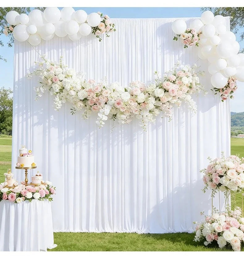 Elegant white pleated drapery backdrop decorated with pink and white floral garlands for weddings and parties