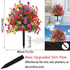 Composition florale vibrante avec des fleurs roses, jaunes et rouges sur un piquet noir pour décoration de jardin