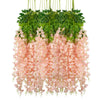 A hanging silk wisteria vine garland featuring green leaves and pink flowers for wedding or home decor.