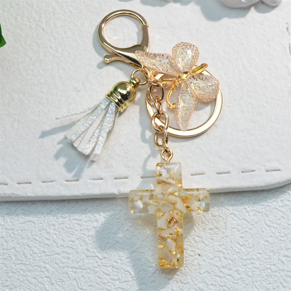 Gold-toned Christian cross butterfly keychain with clear resin charm and white tassel