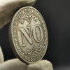 An antique silver-gray decision coin with a floral design is held by a gloved hand.