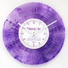 A purple watercolor vinyl record wall clock with a white face and black hands.