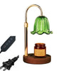A brass adjustable height aromatherapy candle warmer lamp with a green glass shade and a wooden base.