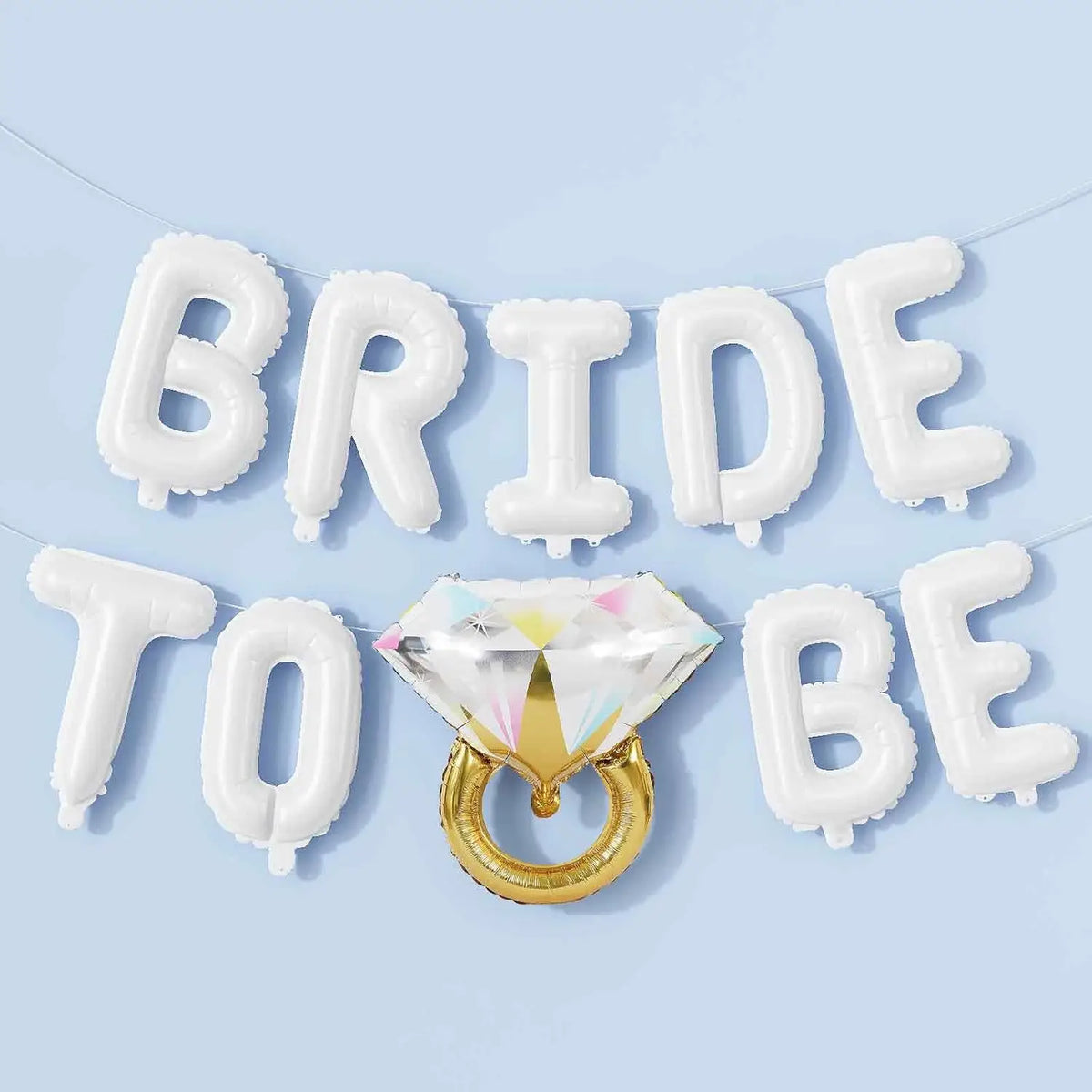 A banner made of white balloon letters spelling BRIDE and TO BE, with a gold diamond ring centerpiece.