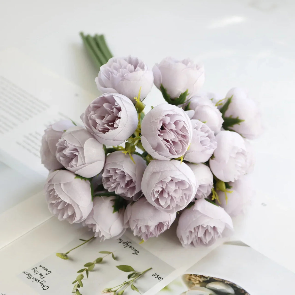 A bouquet of artificial pink peony silk flowers arranged on a white background.