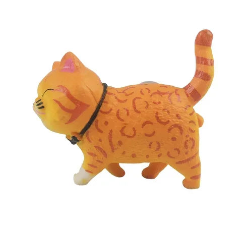 An orange 3D cartoon cat figurine used as a refrigerator magnet.