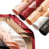 A set of rolled floral wrapping paper in shades of rose gold, pink, and white.