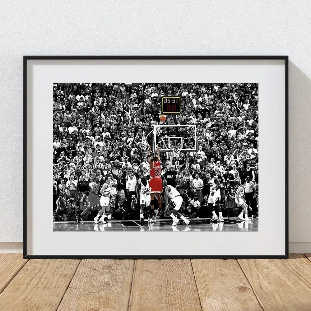 Black and white photo of a basketball game featuring players and a crowd, framed in black.