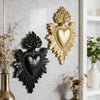 Two gold and black flame heart resin wall decorations mounted on a gray wall.