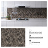 A kitchen countertop featuring a dark marbled backsplash panel with an induction cooktop and modern cabinetry.