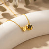 Gold heart and basketball pendant necklace resting on a light surface with soft shadows