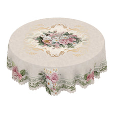 A vintage French floral tablecloth featuring pink and white roses and greenery on a cream fabric.
